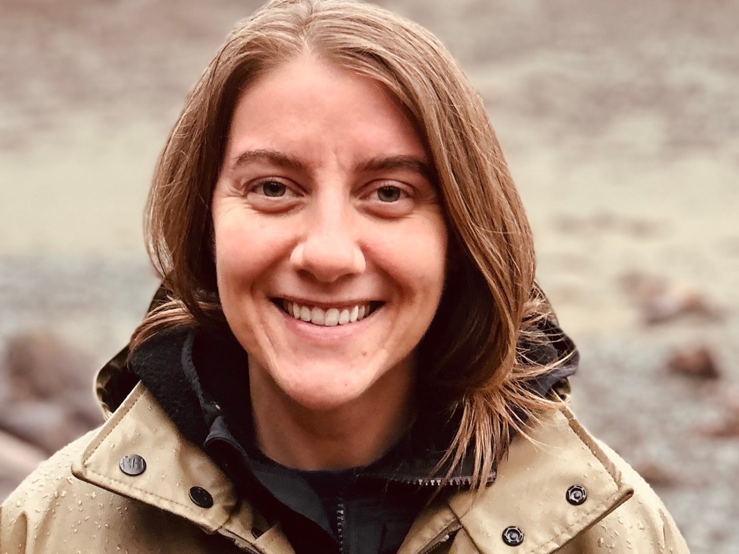 a person wearing a jacket and smiling at the camera